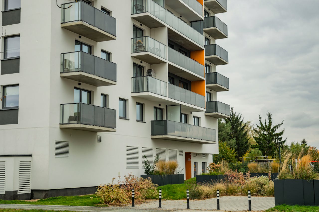 Services Contemporary apartment complex featuring glass balconies and landscaped surroundings.